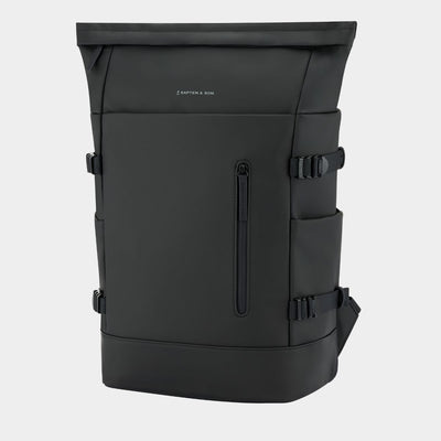 A black backpack with multiple zippered pockets and side buckle straps, shown on a light gray background. The brand name 'KAPTEN & SON' is printed in small white letters on the upper front.