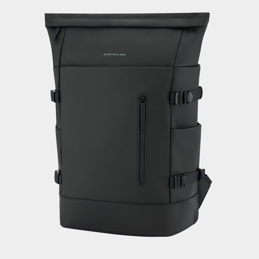 A black backpack with multiple zippered pockets and side buckle straps, shown on a light gray background. The brand name 'KAPTEN & SON' is printed in small white letters on the upper front.