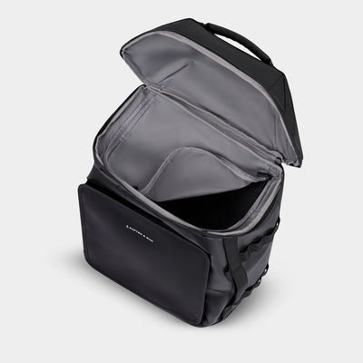 Black backpack with open top compartment on a light grey background