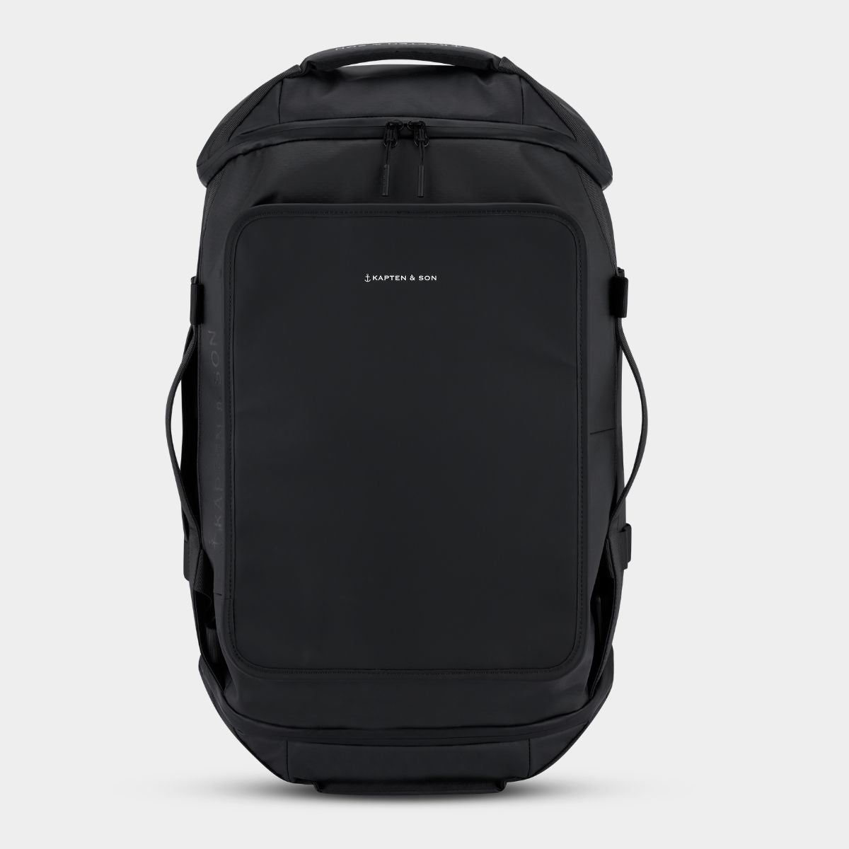 A black backpack/duffle bag with a front zippered pocket and a small white KAPTEN & SON logo on the upper left of the pocket, shown against a plain gray background.