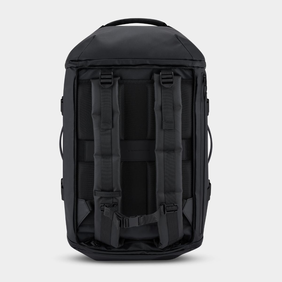 The back view of a black backpack, showing padded shoulder straps, compression buckles, and side carry loops, set against a light gray background.