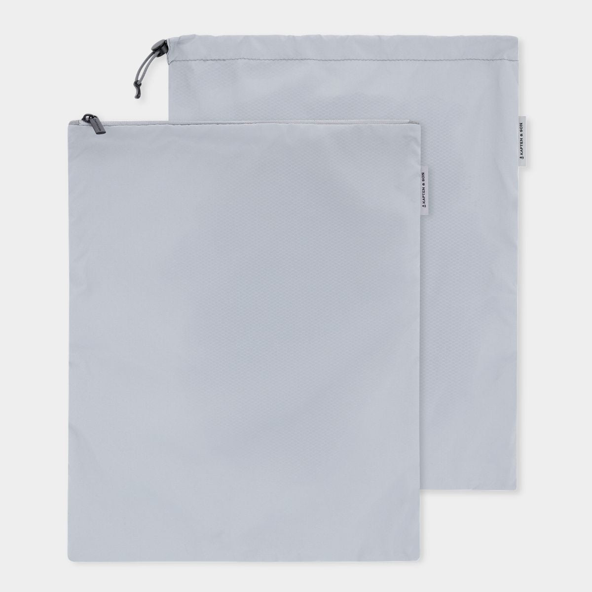 Two light gray drawstring storage bags one with zipper closure and one with draw string, shown overlapping on a clean white background.