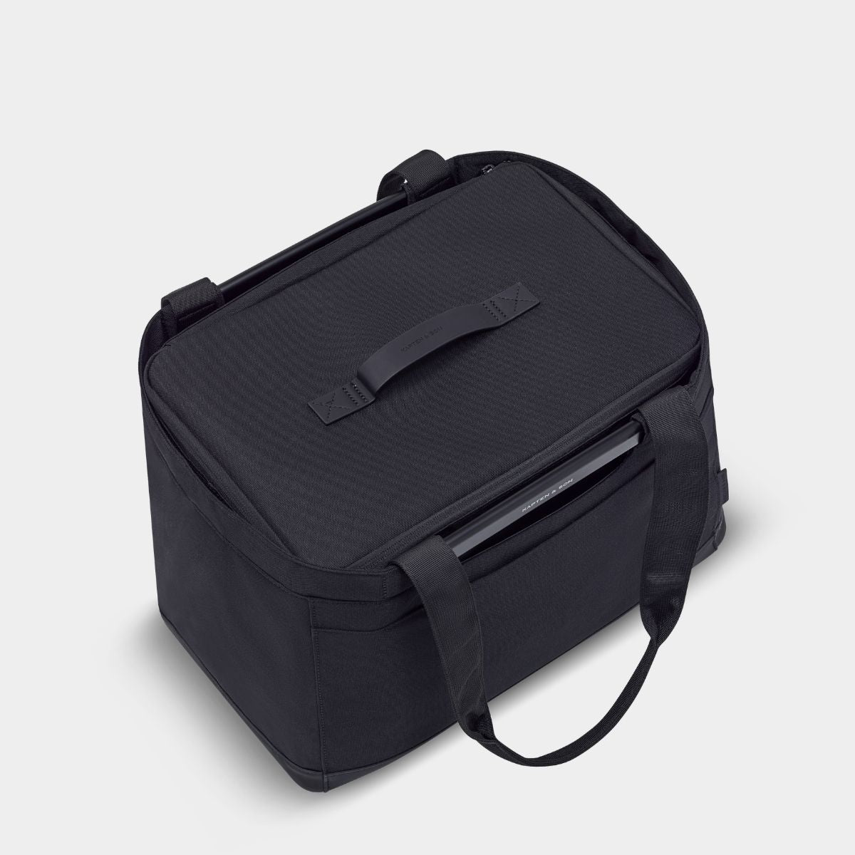 Black soft sides container inside a black basket of the same color with a shoulder strap.. Zipper closure with a top handle.