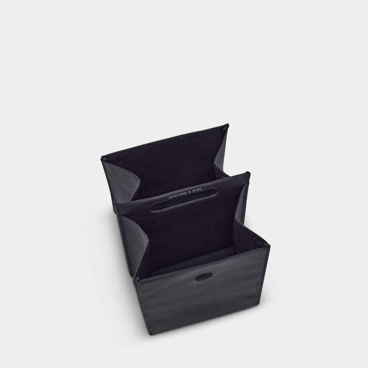 A black fabric organizer box with a fold-out design, shown open on a light gray background.