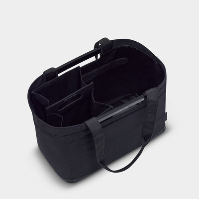 Black tote bag with compartments on a light gray background